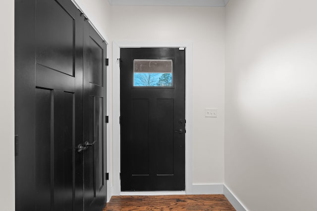 doorway with baseboards and wood finished floors