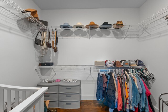 walk in closet with wood finished floors