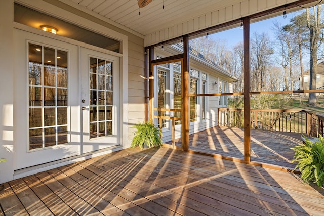 unfurnished sunroom featuring ceiling fan and french doors