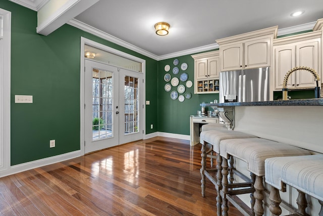 kitchen with dark wood-style floors, ornamental molding, french doors, and stainless steel fridge