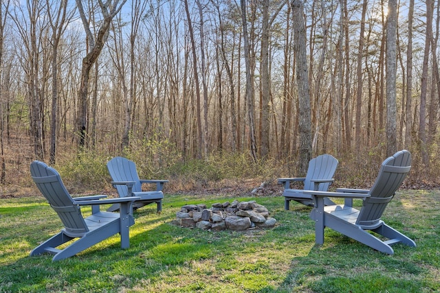 view of yard featuring a fire pit and a view of trees