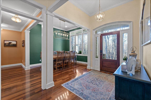 entrance foyer with a notable chandelier, wood finished floors, and ornamental molding