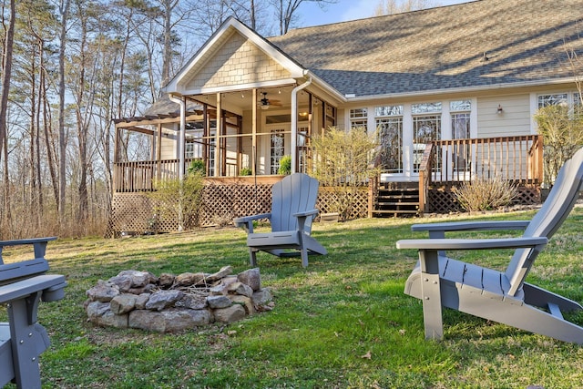 exterior space featuring a fire pit, a wooden deck, and a ceiling fan