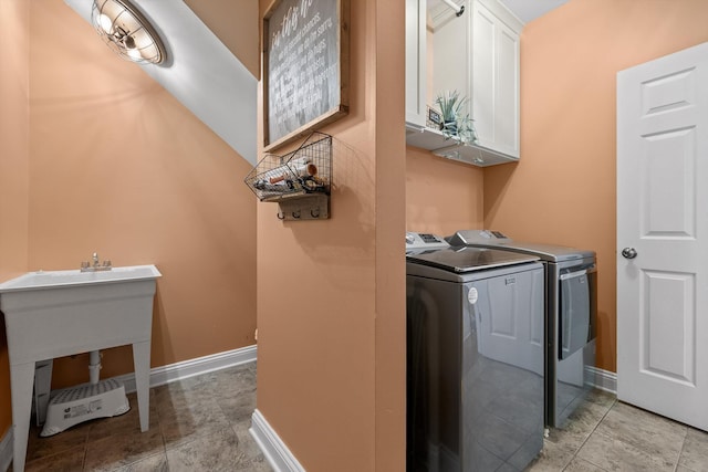 laundry area featuring cabinet space, baseboards, and washer and dryer