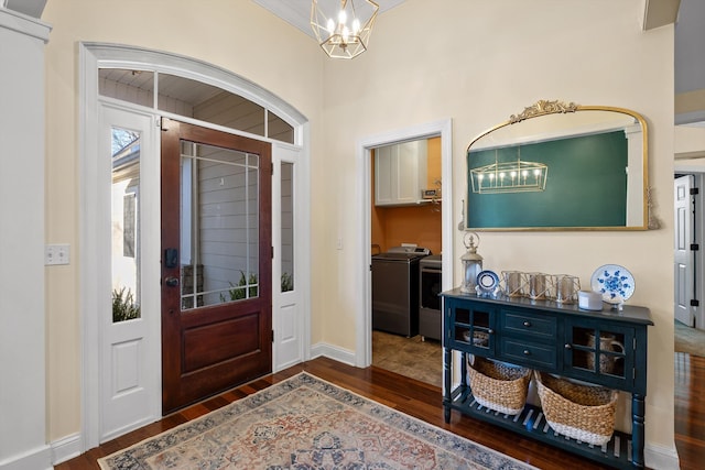 foyer featuring washing machine and clothes dryer, baseboards, a chandelier, and wood finished floors