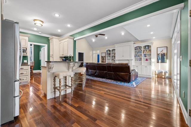 kitchen featuring visible vents, stainless steel appliances, dark wood-type flooring, open floor plan, and a kitchen breakfast bar