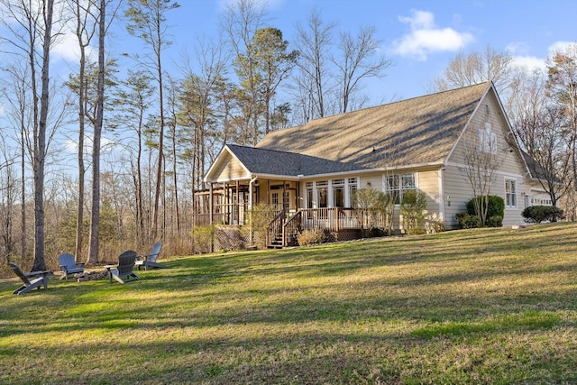 view of front of house featuring a front yard, a shingled roof, and a fire pit