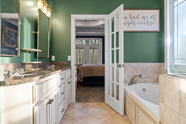 ensuite bathroom featuring tile patterned floors, vanity, french doors, a bath, and ensuite bath