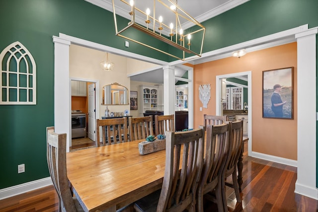 dining room with crown molding, baseboards, wood finished floors, decorative columns, and a high ceiling