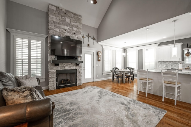 8975 Silver Maple Dr, Ooltewah, TN 37363 - living room with plenty of natural light, a stone fireplace, high vaulted ceiling, and wood finished floors