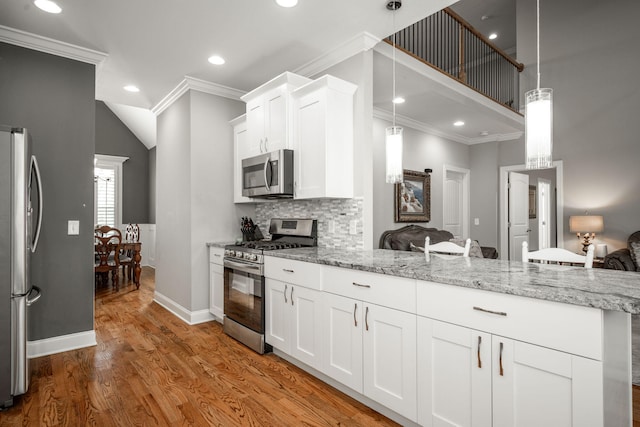8975 Silver Maple Dr, Ooltewah, TN 37363 - kitchen featuring a peninsula, light stone countertops, ornamental molding, stainless steel appliances, and light wood-style floors