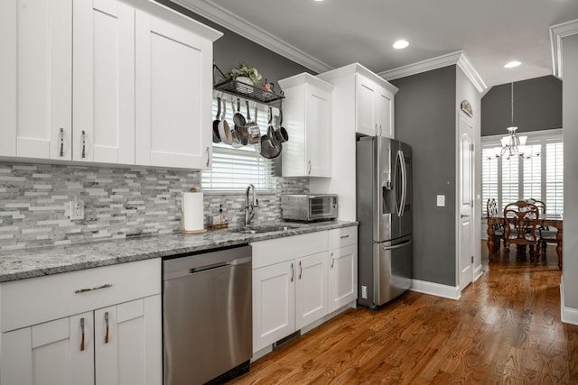 8975 Silver Maple Dr, Ooltewah, TN 37363 - kitchen with ornamental molding, a sink, stainless steel appliances, and a notable chandelier