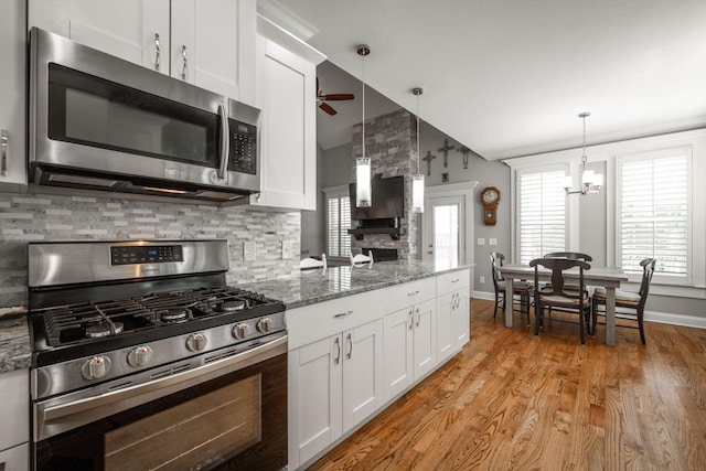 8975 Silver Maple Dr, Ooltewah, TN 37363 - kitchen featuring ceiling fan with notable chandelier, white cabinetry, light wood-type flooring, and appliances with stainless steel finishes