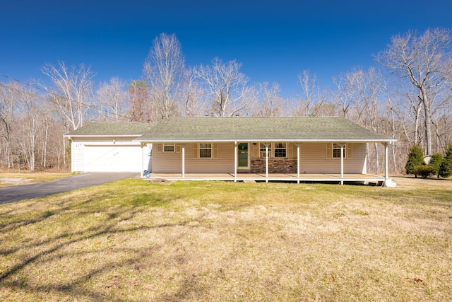ranch-style home with driveway, a front yard, roof with shingles, an attached garage, and a porch