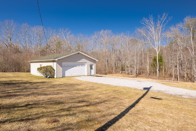 view of property exterior featuring a lawn, an outbuilding, and a garage