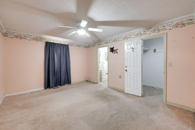 unfurnished bedroom featuring a textured ceiling, crown molding, and carpet