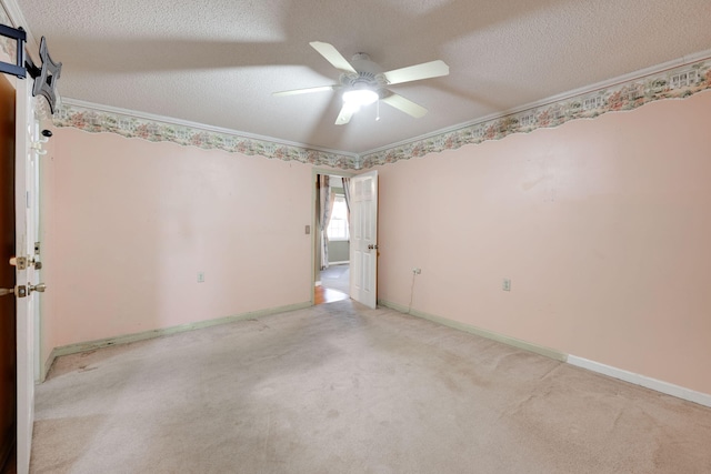 carpeted spare room with ornamental molding, baseboards, ceiling fan, and a textured ceiling