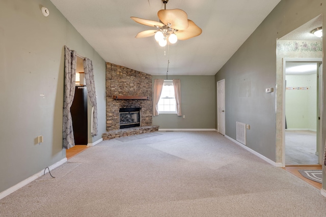 unfurnished living room featuring carpet flooring, a ceiling fan, a stone fireplace, baseboards, and visible vents