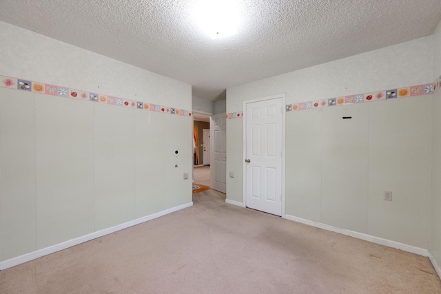 unfurnished room with baseboards, light colored carpet, and a textured ceiling