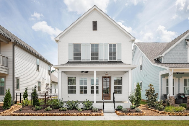 view of front of home with covered porch, brick siding, fence, and ceiling fan
