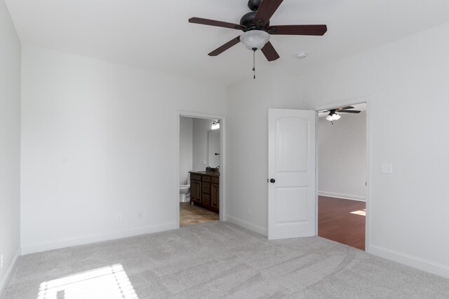 unfurnished bedroom featuring connected bathroom, baseboards, ceiling fan, and carpet