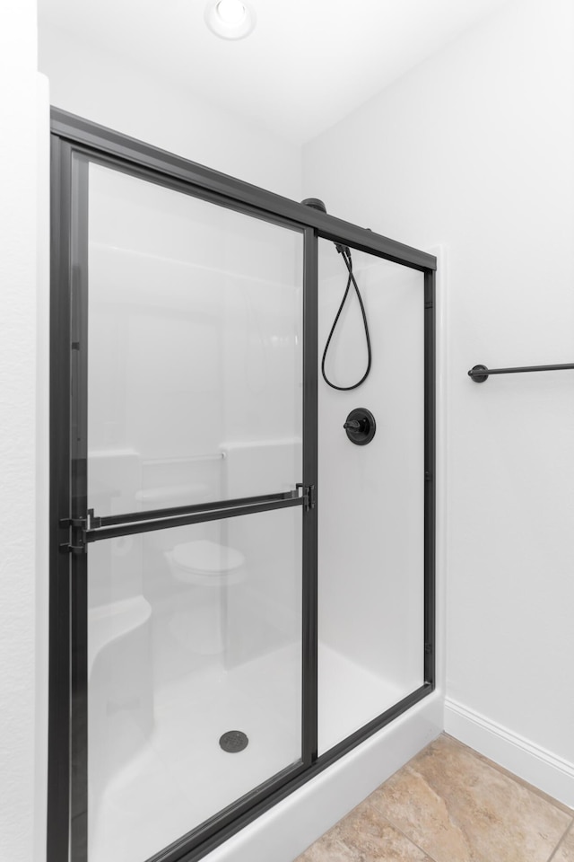 full bathroom with baseboards and a shower stall