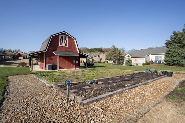view of barn featuring a lawn, central AC, and a residential view