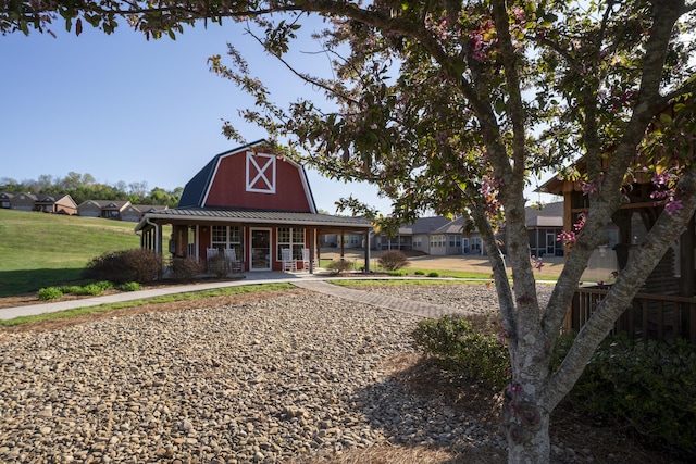 exterior space with metal roof, a barn, a gambrel roof, and a front yard