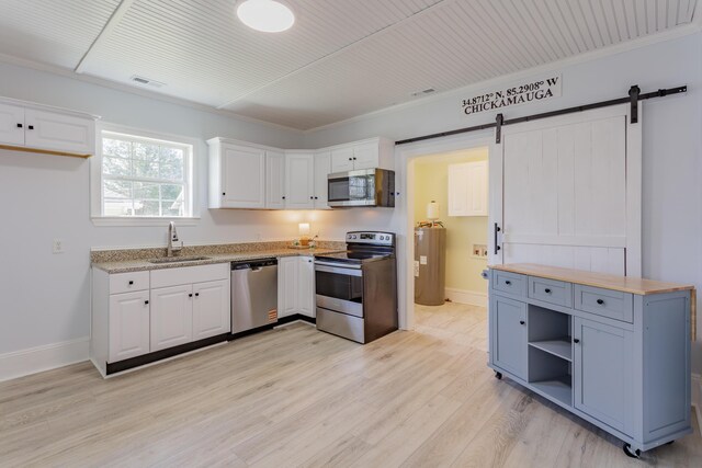 909 Stewart Ave, Chickamauga, GA 30707 - kitchen featuring a sink, light wood finished floors, a barn door, stainless steel appliances, and white cabinets