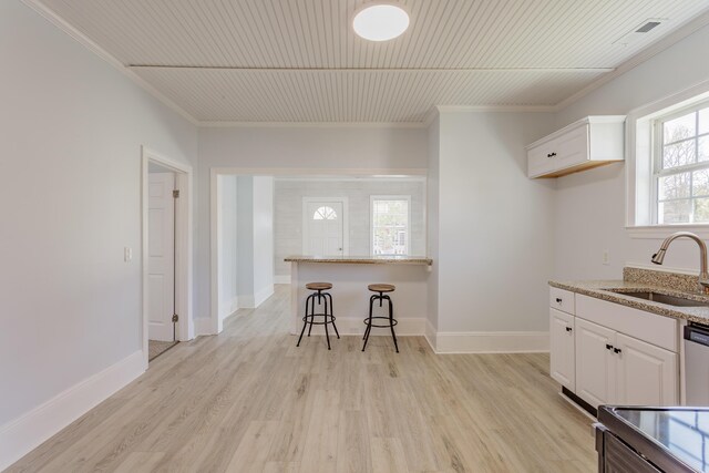 909 Stewart Ave, Chickamauga, GA 30707 - kitchen with white cabinetry, a sink, light wood-style floors, and light stone countertops