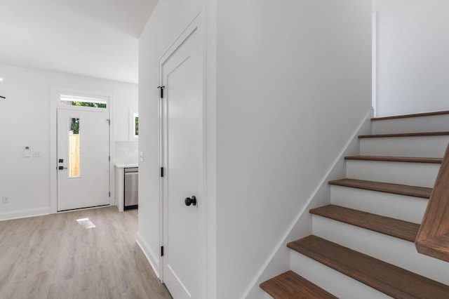 staircase featuring baseboards and wood finished floors