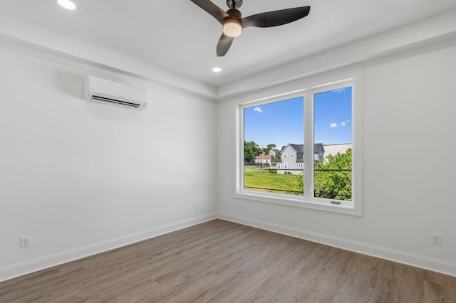 unfurnished room featuring recessed lighting, a wall mounted AC, baseboards, and wood finished floors