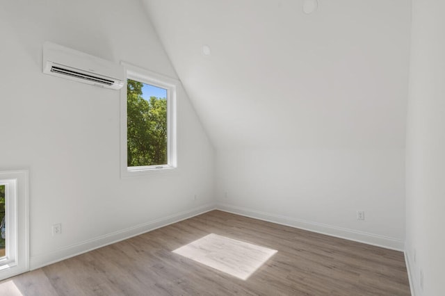 bonus room featuring baseboards, an AC wall unit, lofted ceiling, and wood finished floors