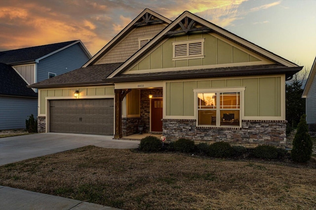 craftsman-style house featuring concrete driveway, an attached garage, stone siding, board and batten siding, and a shingled roof