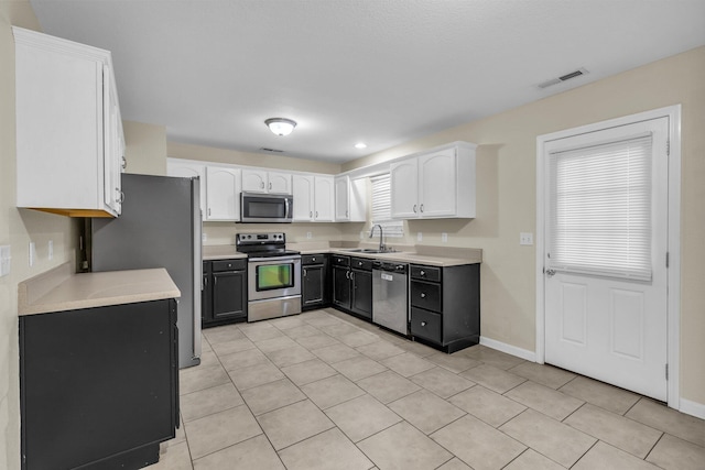 kitchen featuring visible vents, appliances with stainless steel finishes, light countertops, light tile patterned floors, and white cabinets