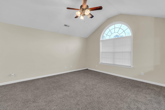 unfurnished room with visible vents, lofted ceiling, baseboards, dark colored carpet, and a ceiling fan