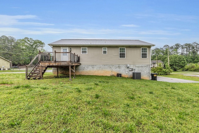 back of property with central air condition unit, a deck, stairway, a lawn, and metal roof