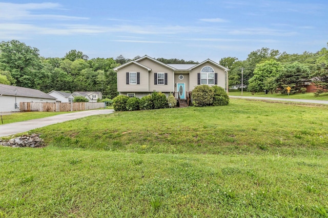 view of front of home featuring fence, driveway, and a front yard