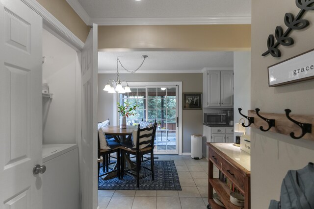 9215 Smokewood Trl, Chattanooga, TN 37421 - dining area with crown molding, light tile patterned flooring, washer / clothes dryer, and a chandelier