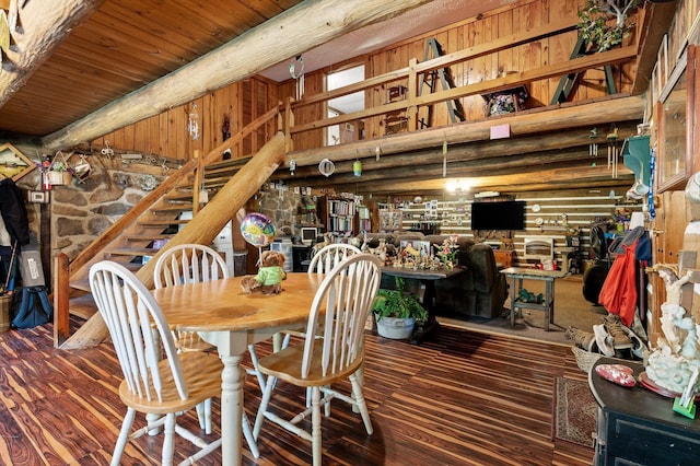 dining room with wood ceiling, beam ceiling, a high ceiling, and wood finished floors