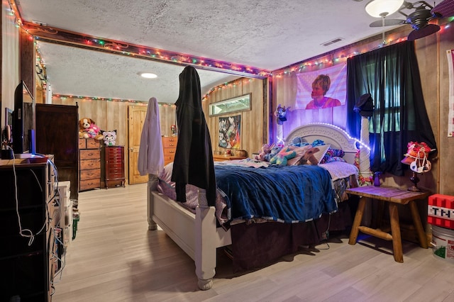 bedroom with a textured ceiling, visible vents, and light wood-style floors