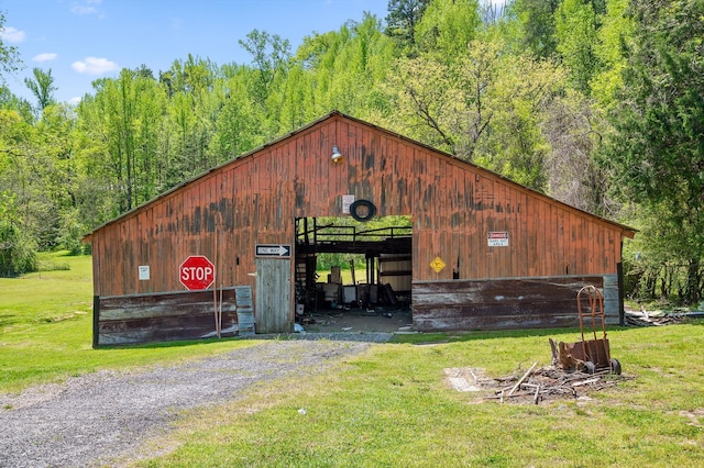 view of pole building with a yard and a forest view
