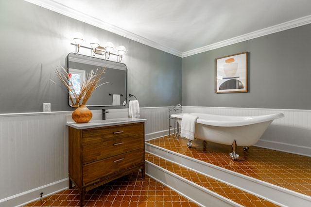 bathroom featuring a soaking tub, vanity, crown molding, and wainscoting
