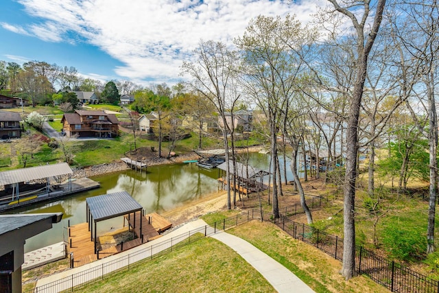 view of water feature with fence, a floating dock, and a residential view