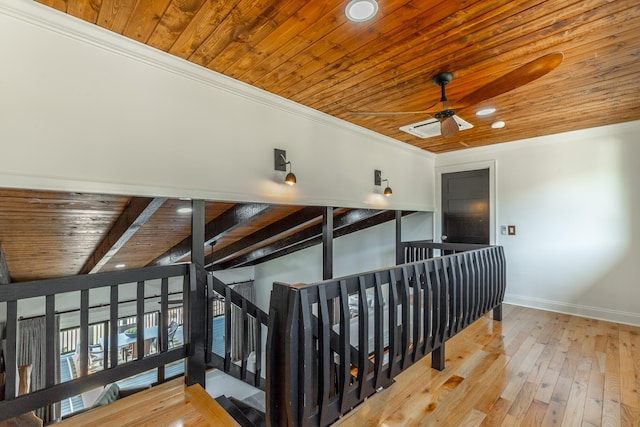 stairs with wood-type flooring, wood ceiling, ornamental molding, and a ceiling fan