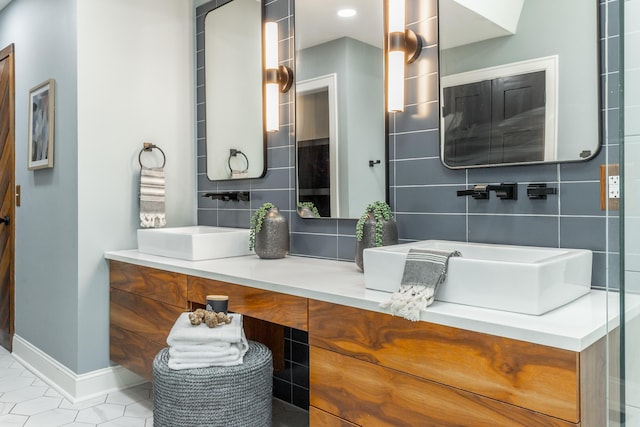 full bathroom featuring baseboards, vanity, and tasteful backsplash