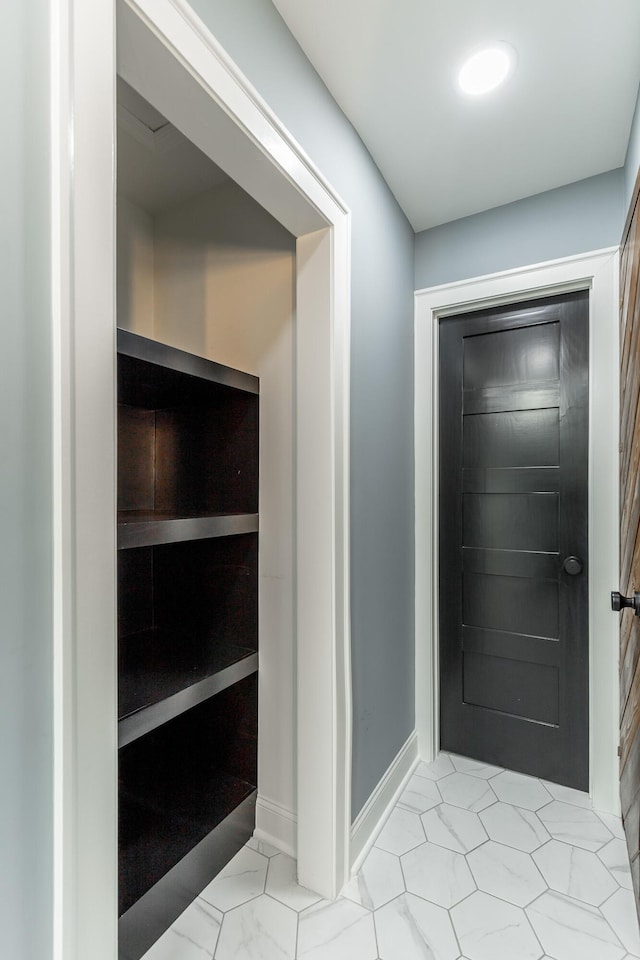 interior space featuring marble finish floor and baseboards