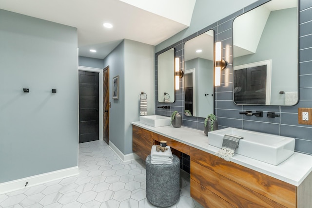 bathroom featuring vanity, tasteful backsplash, baseboards, and recessed lighting