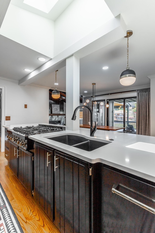 kitchen featuring pendant lighting, light countertops, and a sink