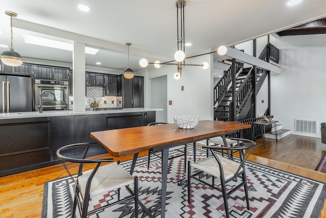 dining room featuring light wood-style flooring, visible vents, baseboards, recessed lighting, and stairway